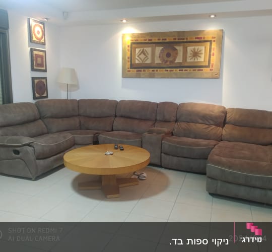 ספה פינתית גדולה בצבע חום בסלון מואר